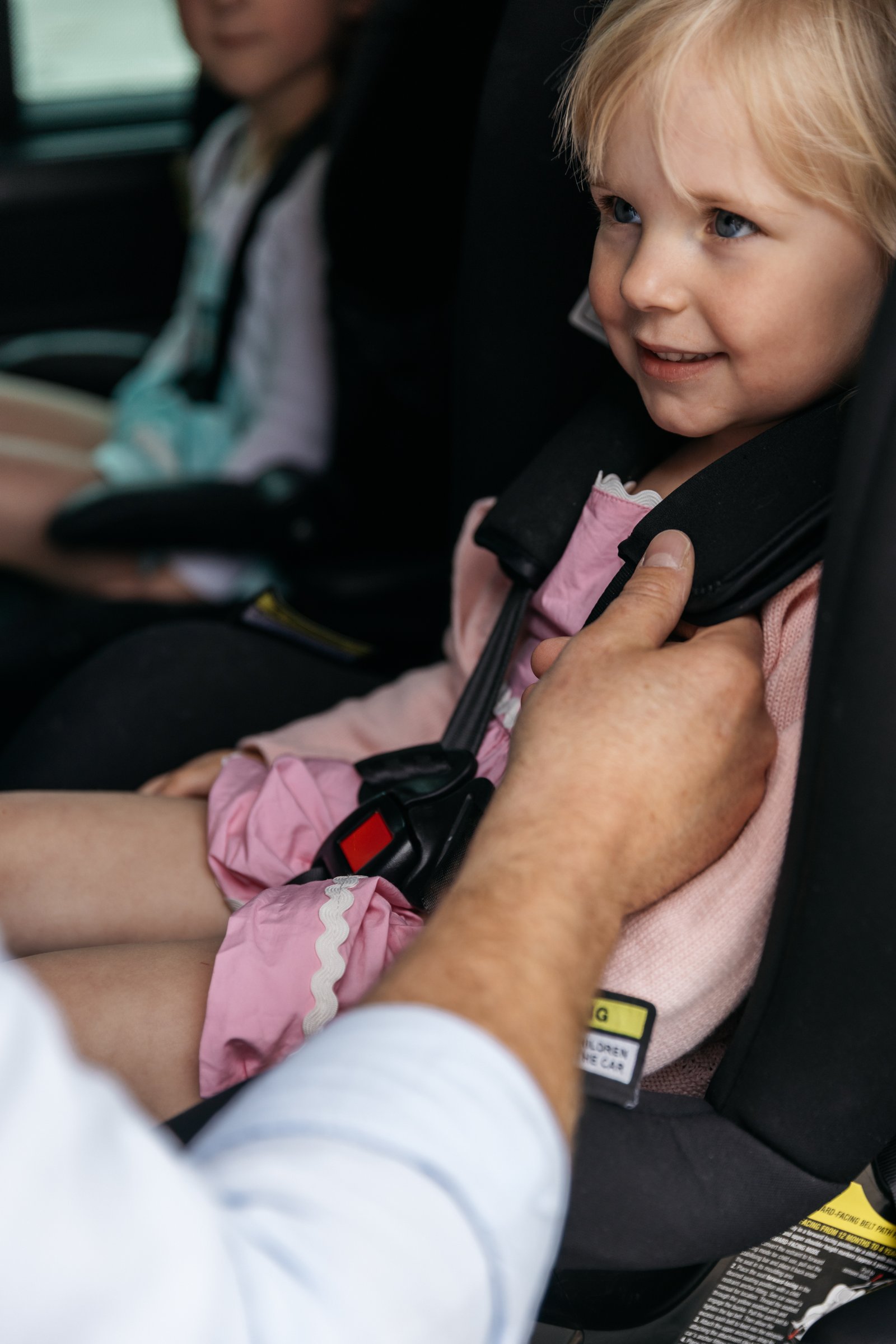 Owner carefully securing a child in a car seat